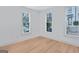 Bright bedroom featuring wood floors and three windows with natural light at 3587 Candler Ct, Hapeville, GA 30354