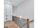 Hallway with wood floors, a wood and metal railing, and white walls at 3587 Candler Ct, Hapeville, GA 30354