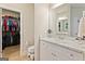Bathroom view of a marble-look vanity with a sink next to a walk-in closet with custom shelving, and wood-look flooring at 344 Dylan Way, Mcdonough, GA 30252