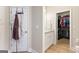 Bathroom shot with door with coat rack, view to vanity with sink and door to walk-in closet with custom shelves at 344 Dylan Way, Mcdonough, GA 30252