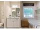 Bright bathroom features vanity and mirror, soaker tub under decorative window and custom shelf and decor at 344 Dylan Way, Mcdonough, GA 30252