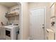 Well-organized laundry room features a washer and dryer, wire shelving and storage and a white door at 344 Dylan Way, Mcdonough, GA 30252
