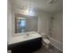 Bathroom features a vanity with modern fixtures, a large mirror, and a shower-tub combo at 7253 Lacey Dr, Douglasville, GA 30134
