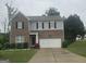 Two-story home featuring brick and siding, a two-car garage, and a well-maintained front lawn at 7253 Lacey Dr, Douglasville, GA 30134