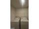 A compact laundry room includes a washer, dryer, and a wire shelf for storage at 7253 Lacey Dr, Douglasville, GA 30134
