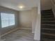 Neutral living room featuring hard surface flooring, large window, and staircase at 7253 Lacey Dr, Douglasville, GA 30134