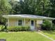 Inviting single-story home with a light yellow exterior, white trim and shutters, and manicured landscaping at 520 Mcdonough Rd, Hampton, GA 30228