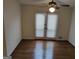 Bedroom featuring hardwood floors, ceiling fan, and access to a private patio at 7640 Ryefield Dr, Sandy Springs, GA 30350