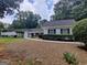 Ranch-style home with a white brick exterior, well-maintained landscaping, and a concrete pathway leading to the front door at 7640 Ryefield Dr, Sandy Springs, GA 30350