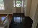 Foyer with black tile floors and beautiful front door; staircase nearby leads to hardwood floors at 7640 Ryefield Dr, Sandy Springs, GA 30350