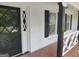 Charming front porch with brick flooring, diamond pane windows and black trim accents at 7640 Ryefield Dr, Sandy Springs, GA 30350