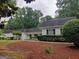 Traditional white home with a lush, landscaped front yard and manicured hedges at 7640 Ryefield Dr, Sandy Springs, GA 30350
