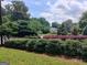 Street view of a home showcasing lush landscaping with manicured shrubs, colorful flowerbeds, and mature trees enhancing curb appeal at 7640 Ryefield Dr, Sandy Springs, GA 30350