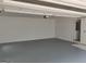 Clean and organized garage with painted floors and walls, featuring an entry door and overhead storage racks for functionality at 7640 Ryefield Dr, Sandy Springs, GA 30350