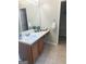 Bathroom vanity with cabinets, a sink, a large mirror, and a view into an adjacent closet at 2517 Walter Way, Stockbridge, GA 30281