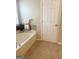 Bathroom showcasing a soaking tub with tiled surround, along with a white door at 2517 Walter Way, Stockbridge, GA 30281