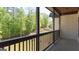 View of the porch with a railing, brick facade, wood ceiling and a view to the green landscaped yard at 10765 Shallowford Rd, Roswell, GA 30075