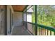 View of the porch with a railing, brick facade, wood ceiling and a view to the green landscaped yard at 10765 Shallowford Rd, Roswell, GA 30075