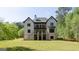 Exterior rear view of house with balconies, stairs, and a large backyard at 10765 Shallowford Rd, Roswell, GA 30075