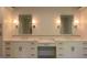 Elegant bathroom vanity with double sinks, sconces, white cabinetry and marble countertop at 10765 Shallowford Rd, Roswell, GA 30075