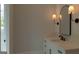 Bathroom featuring vanity with marble countertop, mirror and sconces at 10765 Shallowford Rd, Roswell, GA 30075