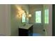 Bathroom vanity featuring marble countertop, gold fixtures, mirror and sconces at 10765 Shallowford Rd, Roswell, GA 30075
