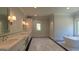 Modern bathroom with marble floors, double vanity, sleek lighting, and a soaking tub at 10765 Shallowford Rd, Roswell, GA 30075
