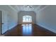 Large bedroom featuring hardwood floors, tray ceilings, and a window at 10765 Shallowford Rd, Roswell, GA 30075