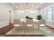 Elegant dining room featuring classic wall paneling, modern light fixture, and large windows, perfect for formal dinners at 10765 Shallowford Rd, Roswell, GA 30075