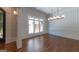 Bright dining room featuring hardwood floors, detailed trim, a modern chandelier, and a large window at 10765 Shallowford Rd, Roswell, GA 30075