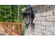 Close up of a brick wall with an outdoor light fixture and a built in camera/intercom at 10765 Shallowford Rd, Roswell, GA 30075