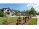 View of several luxury houses with well manicured lawns, driveways, and a split rail fence at 10765 Shallowford Rd, Roswell, GA 30075