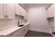 Laundry room features a utility sink, ample storage and counter space at 10765 Shallowford Rd, Roswell, GA 30075