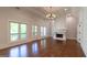 Bright, open living area with dark wood floors, fireplace, and a charming chandelier at 10765 Shallowford Rd, Roswell, GA 30075
