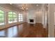 Spacious living room with hardwood floors, a fireplace, large windows, and detailed trim at 10765 Shallowford Rd, Roswell, GA 30075