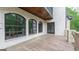An outdoor patio featuring brick walls, tile flooring, large windows, and a door to the backyard at 10765 Shallowford Rd, Roswell, GA 30075