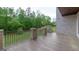 Patio with dark-stained wood look tile, wrought iron railing, and manicured yard at 10765 Shallowford Rd, Roswell, GA 30075