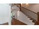 Elegant staircase with wood and iron railing complemented by hardwood floors and decorative wall trim at 10765 Shallowford Rd, Roswell, GA 30075