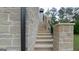 Stone staircase leading up to the house, flanked by stone walls and a black railing at 10765 Shallowford Rd, Roswell, GA 30075