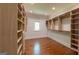 Walk-in closet featuring hardwood floors, recessed lighting, shelving, and a window at 10765 Shallowford Rd, Roswell, GA 30075