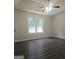 Bright bedroom with hardwood floors, ceiling fan, and a large window with backyard views at 54 Crestwood Dr, Dallas, GA 30157