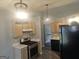 Well-lit kitchen featuring stainless steel stove and black refrigerator adjacent to the stairway at 54 Crestwood Dr, Dallas, GA 30157