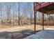 Backyard with mature trees seen from underneath a wooden deck featuring a partial fence at 145 Windward Hls, Mcdonough, GA 30253
