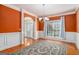 Formal dining room featuring hardwood floors, orange walls, wainscoting, and decorative lighting at 145 Windward Hls, Mcdonough, GA 30253