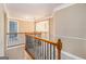 Upstairs hallway with wood railing and view of the foyer below at 145 Windward Hls, Mcdonough, GA 30253
