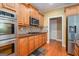 Kitchen featuring wood cabinets, stainless steel appliances, hardwood floors, and ample countertop space at 145 Windward Hls, Mcdonough, GA 30253
