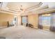 Large primary bedroom with tray ceiling, ceiling fan, and windows overlooking the backyard at 145 Windward Hls, Mcdonough, GA 30253