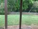 View of a fenced backyard with green grass and mature trees from a screened porch at 2667 Hampton Park Dr, Marietta, GA 30062