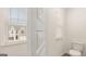 Bathroom featuring a toilet, neutral wall paint, and window with natural light at 325 Silver Moon Dr, Loganville, GA 30052