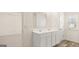 Bright bathroom featuring a double sink vanity and a view into the bedroom at 325 Silver Moon Dr, Loganville, GA 30052